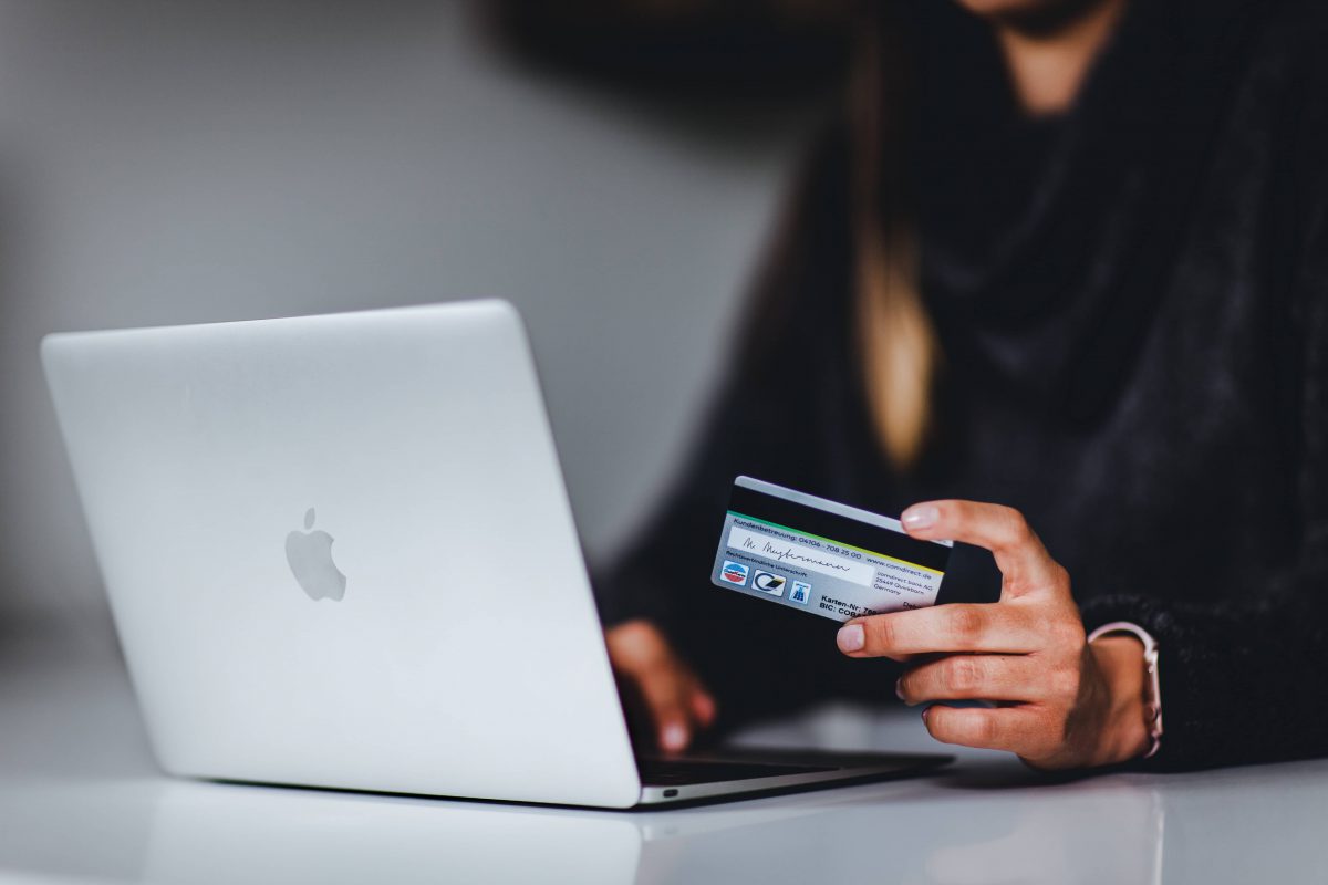 femme devant un e-commerce avec carte de crédit en main