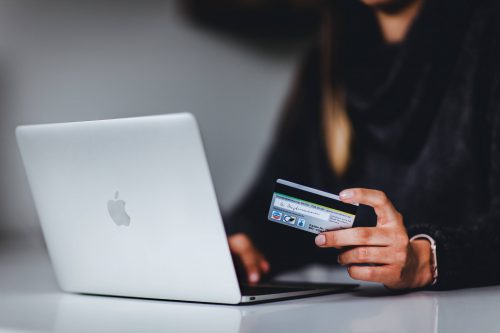 femme devant un e-commerce avec carte de crédit en main