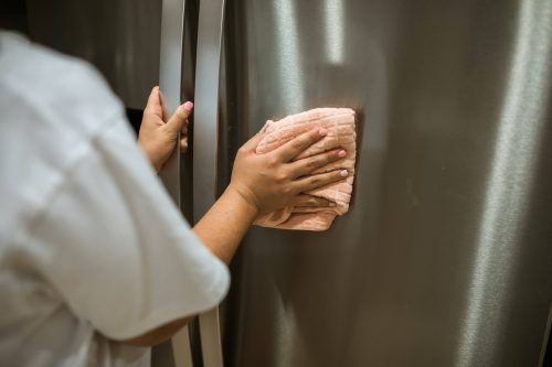 une personne qui nettoie un réfrigérateur
