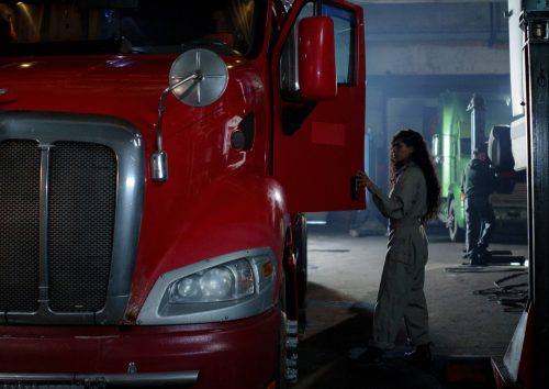 femme montant dans son camion rouge